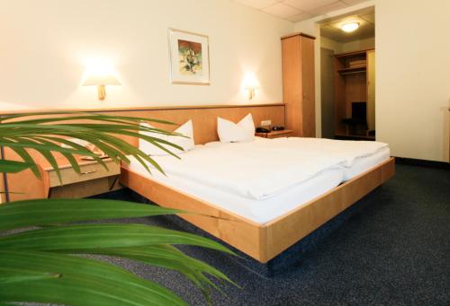 A bed or beds in a room at Kurparkhotel Das Kleinod