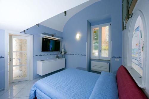 a blue bedroom with a bed and a tv at Casa Amore S Lucia in Amalfi