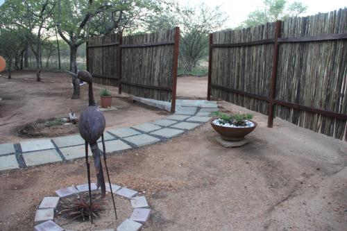 a bird statue in a yard with a fence at Mushi Maningi in Hoedspruit