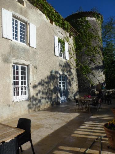 a patio with tables and chairs in a building at Chateau de Mauras in Chomérac