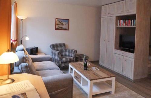 ein Wohnzimmer mit einem Sofa und einem TV in der Unterkunft Inselresidenz Strandburg Juist - Wohnung 107 (Ref. 52044) in Juist