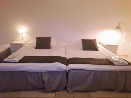 a large bed in a room with two lamps at VillaVega Apartments in Lund