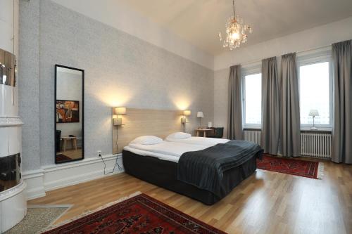 - une chambre avec un grand lit et un miroir dans l'établissement First Hotel City Eskilstuna, à Eskilstuna