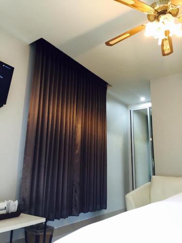 a bedroom with a window with brown curtains at Relax Resort in Nakhon Sawan