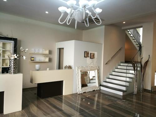 a living room with a staircase and a chandelier at Hotel Bruman in Caserta