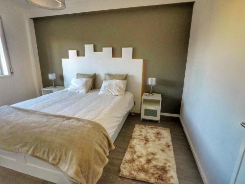 a bedroom with a large white bed and a rug at House Colegio de Gaia in Vila Nova de Gaia