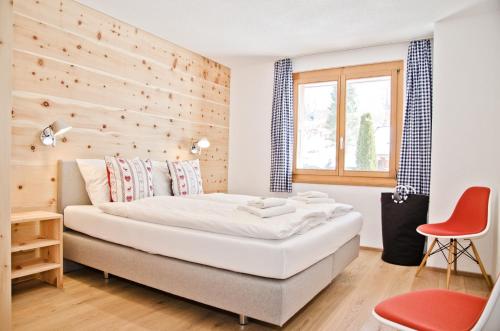 Apartment Matterhorn - GRIWA RENT AG في جريندلفالد: غرفة نوم بسرير وجدار خشبي