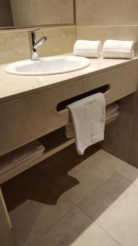 y baño con lavabo, espejo y toallas. en Hotel UOM Buenos Aires en Buenos Aires