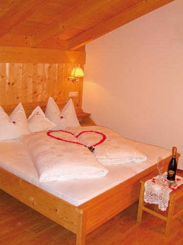a bed with a red ribbon on top of it at Gasthof Weisses Kreuz in Naturno