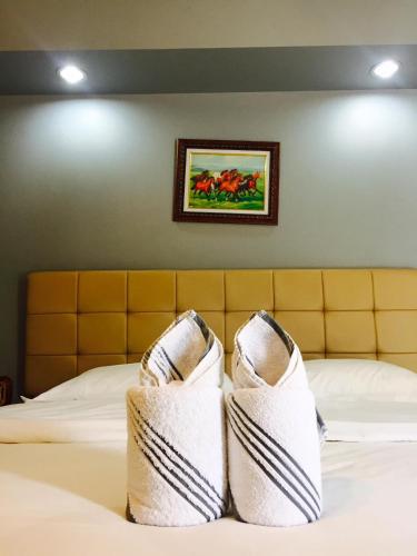 a bed with two white socks on top of it at Relax Resort in Nakhon Sawan