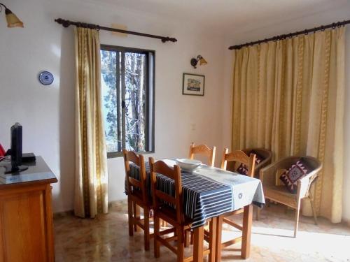 a dining room with a table and chairs and a window at Apartamento Jordi in Cala Figuera