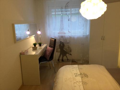 a bedroom with a bed and a desk and a lamp at Fewo Bella Margitta Baumann in Stegen