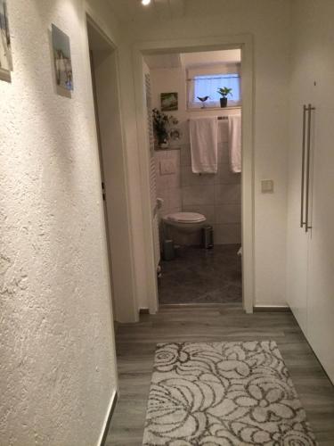 a hallway with a bathroom with a toilet and a sink at Fewo Bella Margitta Baumann in Stegen