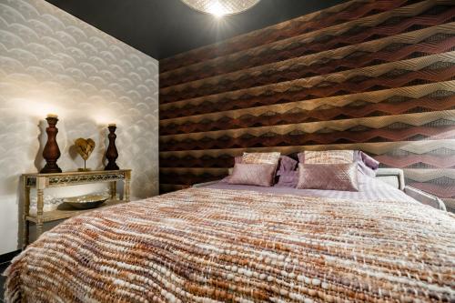 a bedroom with a large bed with a wooden wall at Casa Lavanda in Zottegem