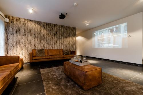 a living room with a couch and a large screen at Casa Lavanda in Zottegem