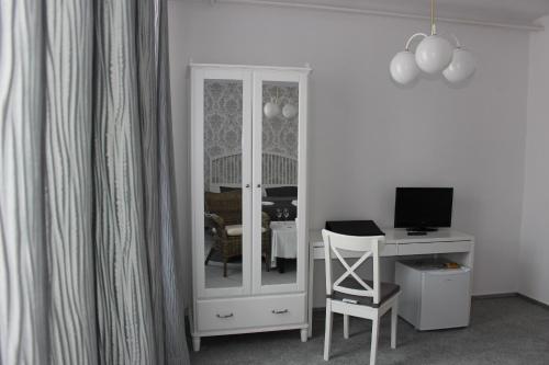 a room with a computer and a desk with a mirror at Hotel Amadeus in České Budějovice