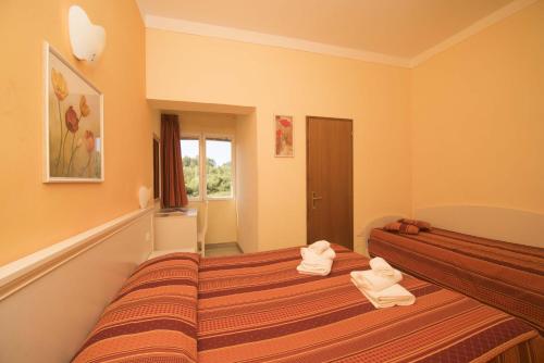 zwei Betten in einem Zimmer mit Handtüchern darauf in der Unterkunft Hotel Etrusco in Rio Marina