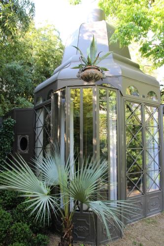 a greenhouse in a garden with two plants in it at La Divine Comédie-Suites Deluxe in Avignon