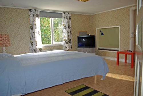 a bedroom with a large white bed and a window at Solhem in Älmeboda
