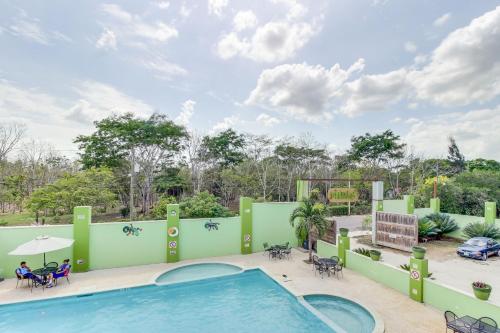 a pool at a resort with tables and chairs at Midas Belize in Trapiche