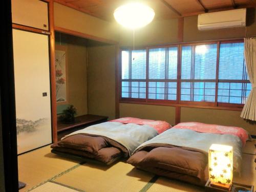 Tempat tidur dalam kamar di Murasakino Guesthouse