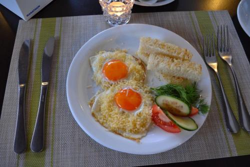 a plate with eggs and bread and vegetables on a table at Hata Hutsula in Mykulychyn