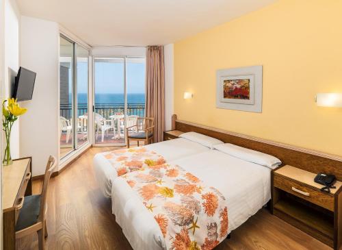 プラヤ・デル・イングレスにあるRelaxia Beverly Parkのベッド付きのホテルルームで、海の景色を望めます。