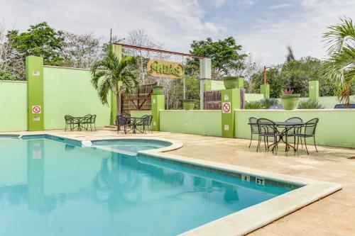 a pool at a hotel with chairs and a restaurant at La Casita at Midas Belize in Trapiche