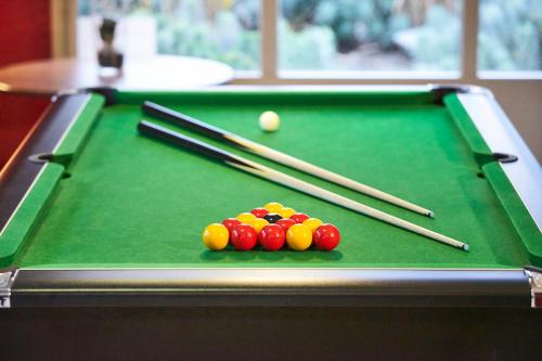a green pool table with cue balls and chopsticks at Campanile NATURE - Epône in Épône