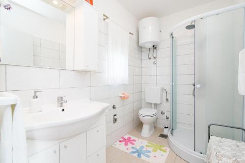 een witte badkamer met een wastafel en een toilet bij Apartment Seventh Heaven in Podstrana