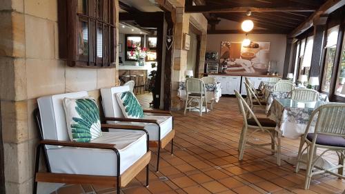 une chambre avec des chaises et une table ainsi qu'une cuisine dans l'établissement Hotel Colegiata, à Santillana del Mar