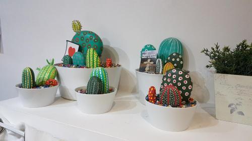 a group of cactus plants in white pots on a shelf at Hotel Colegiata in Santillana del Mar