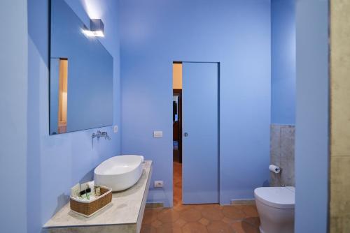 a bathroom with a sink and a toilet and a mirror at Villa Socini in Siena