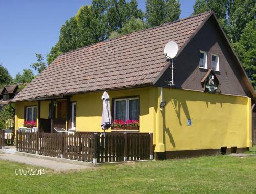 ブルクにあるFerienwohnung 1 am Bismarckturm in Burgの褐色の屋根と柵の黄色い家