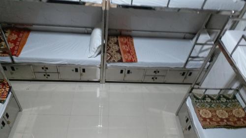 a room with three bunk beds on the floor at One Step Hostel in Mumbai