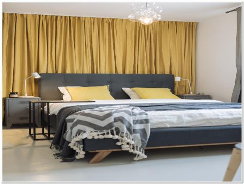 a bedroom with a large bed with yellow pillows at Old Town Studio - Panoramic City View in Bucharest
