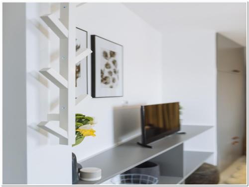 a living room with a television on a shelf at Old Town Studio - Panoramic City View in Bucharest