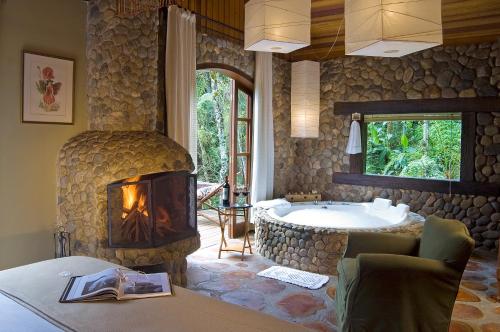 a bathroom with a fireplace and a bath tub at Casa da Colina Chalés in Visconde De Maua
