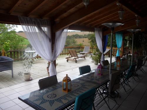 a patio with a table and chairs on a deck at Chambres d'Hôtes Gelous in Bidache