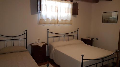 トルトリにあるcasaのベッドルーム1室(ベッド2台、窓付)