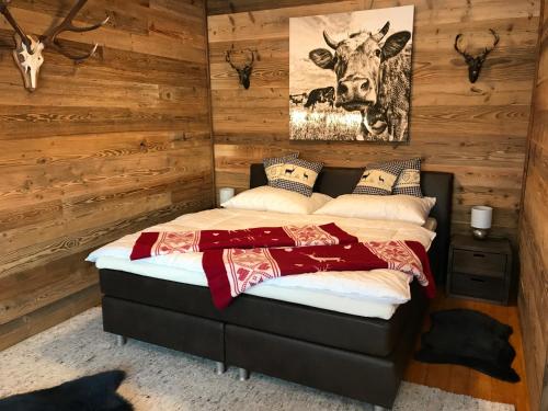 a bedroom with a bed with a cow picture on the wall at Bergblick Walchsee in Walchsee