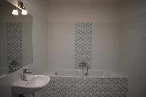 a bathroom with a sink and a bath tub at Hotel Dvůr in Krnsko