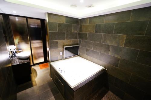 a bathroom with a bench and a sink in it at Formosa Motel & Inn in Changhua City