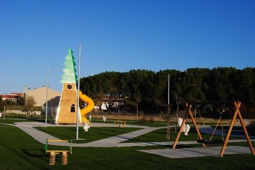um parque com um parque infantil com uma torre e baloiços em camera zona policlinico/università em Monserrato