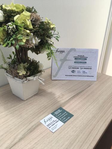 a table with a potted plant and a card on it at Fragga Hospedaje Boutique in Antofagasta