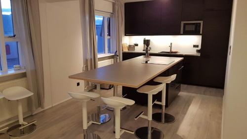 a kitchen with a wooden table and stools at Post-Plaza Guesthouse in Húsavík