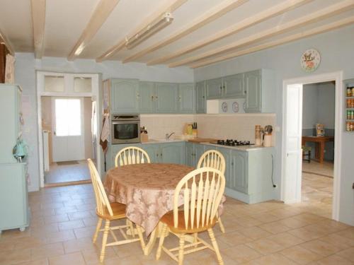 a kitchen with a table and chairs in a kitchen at Bed and Breakfast Dunroamin in Couture-dʼArgenson