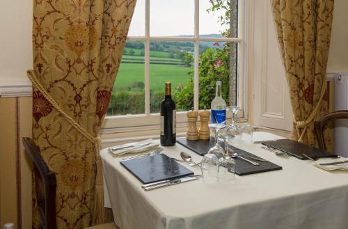 a table with a white table cloth and a window at Beera Farmhouse in Milton Abbot