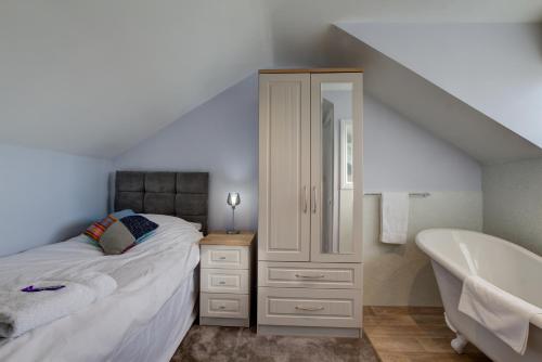 a bedroom with a bed and a bath tub at Sunrise Guest House in Bude