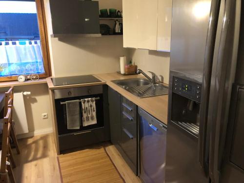 a kitchen with a stainless steel refrigerator and a sink at Nordsee-Lilie in Wilhelmshaven